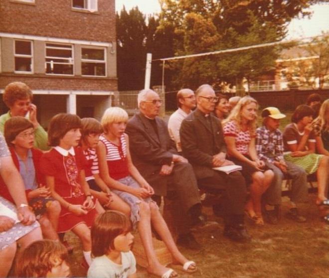 0165 : COMBLAIN-LA-TOUR : Autour de l’ognisko : Autour de Ks Kurzawa, il me semble qu’il y ait des enfants venus d’Allemagne ; l’autre prêtre est Ks Kejke d’Allemagne aussi. A gauche de Ks Kurzawa : Bronia Hordynski de Saint-Vaast. A l’extrême gauche : la dame avec un gilet vert est Madame Wojas de Liège, elle travaillait aux cuisines et venait avec ses 2 filles : Gisèle et Fabiola Wojas. 