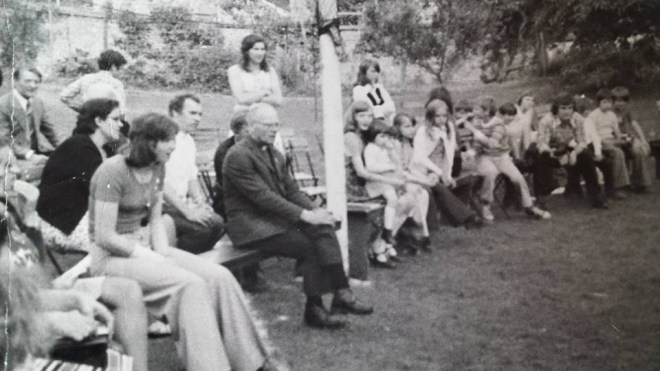 0166 : COMBLAIN-LA-TOUR : Autour de l’ognisko : Mr Jozeph Rzemieniewski ; Annie Nowicki ; Ks Kurzawa ; Pelagie Nowicki ;  À droite du mât : Fabienne Laffut qui materne ses tout-petits dont peut-être Betty Nowicki avec de longs cheveux et plus à droite : Henry Bogdanski de la région du Centre. 